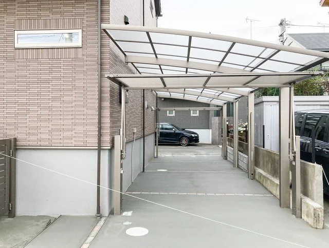 土間コンクリートの駐車場と目隠しフェンスを備えた住宅外構